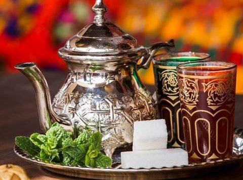 Here’s a recipe for Moroccan Mint Tea, a beloved and refreshing drink that is an essential part of Moroccan hospitality. It's made with green tea, fresh mint leaves, and sugar, and served in a traditional way. Ingredients: 1 tablespoon loose green tea (preferably Chinese gunpowder green tea) 1-2 sprigs of fresh mint (about 20-25 leaves) 3-4 cups boiling water 2-3 tablespoons sugar (or to taste) Optional: 1-2 cardamom pods (for extra flavor) Instructions: Rinse the Tea: In a teapot, add the loose green tea leaves. Pour in about a cup of boiling water over the tea leaves and swirl it around for a few seconds. This helps to rinse the tea and remove any bitterness. Discard this water. Brew the Tea: Add about 3 cups of boiling water to the tea leaves in the teapot. Let it steep for 5 minutes to brew the tea. Add the Mint and Sugar: While the tea is brewing, rinse the fresh mint sprigs under cold water. Once the tea has steeped, add the fresh mint leaves and sugar to the teapot. Stir well to dissolve the sugar. Steep and Mix: Allow the tea to steep for another 5-10 minutes. The longer it steeps, the more aromatic the mint will become. If you like a stronger mint flavor, you can crush the mint slightly with a spoon or muddler. Serve: To serve traditionally, pour the tea from a height into small glasses. This helps to aerate the tea and create a frothy top. If you prefer, you can strain the tea before serving to remove the mint leaves and tea leaves. Optional Flavoring: If you like extra flavor, you can add a couple of lightly crushed cardamom pods to the tea while it’s brewing. Tips: Sweetness: Moroccan mint tea is traditionally served very sweet, but you can adjust the sugar to your liking. For a less sweet version, start with 1 tablespoon of sugar and adjust from there. Serving: Moroccan mint tea is typically served in small glasses, often accompanied by Moroccan pastries or sweets. Moroccan Mint Tea is a symbol of hospitality and a refreshing way to enjoy a sweet, aromatic drink. It’s perfect for cooling off on a warm day or enjoying with friends and family!